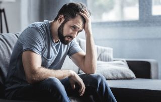 goodencenter-10-symptoms-of-depression-photo-of-a--Sad-unhappy-handsome-man-sitting-on-the-sofa