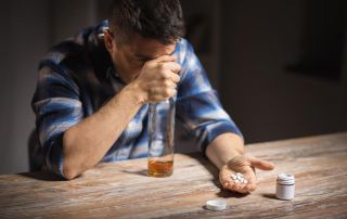 goodencenter-Why-Alcohol-and-Antidepressants-Should-Not-be-Mixed-photo-of-unhappy-drunk-man-with-bottle-of-alcohol-and-pills